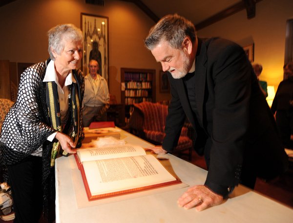 Jungian analyst Virginia Krauft, left, shows her copy of Carl Jung’s “Red Book” to the Rev. Lowell Grisham, rector of St. Paul’s Episcopal Church in Fayetteville. The Northwest Arkansas Friends of Jung group has donated copies of the seminal work to the Fayetteville Public Library and the library at St. Paul’s, where the group has been meeting for 23 years.
