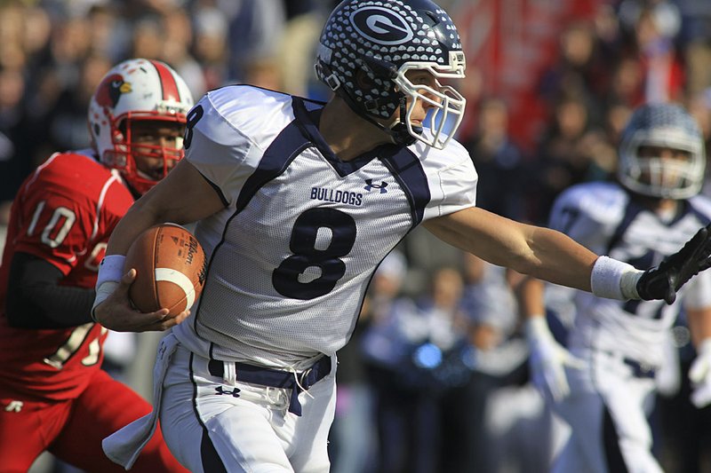  Greenwood quarterback Stephen Hogan shakes off a tackle in the Class 5A State Championship Game at War Memorial Stadium in 2010. The Bulldogs, which have won four state football titles since 2005, will move to Class 6A. 