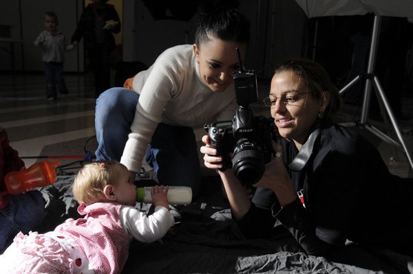  Beth Hall, right, shows Jessica Tweedy a picture of her daughter Madisyn Ware, nine months, at the Help-Portrait Northwest Arkansas Saturday Dec. 4, 2010 at St. Paul's Episcopal Church in Fayetteville. The event brought several photographers together to provide professional portraits to families in need during the holiday season. Each participant received a photo CD with the images from the shoot and a small selection of prints.