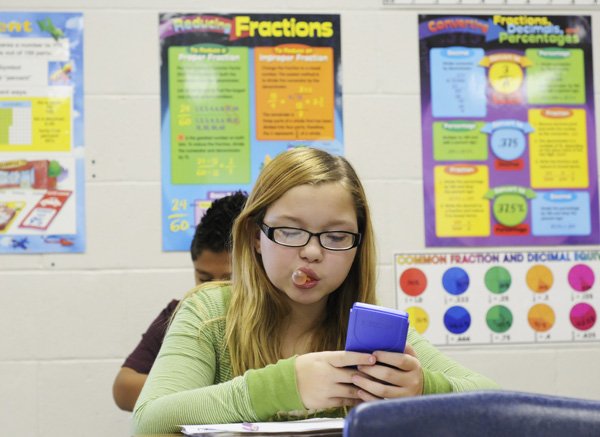 Brianna Henley, 11, works on a math problem Thursday in Krista Webb’s sixth grade math class at Elmwood Middle School in Rogers.