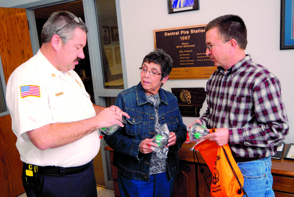 Benton Fire Chief Chris Campbell, left, donor Ameila Frazier and Dr. Scott Toms discuss the oxygen masks designed specifically to help rescue pets in fires.