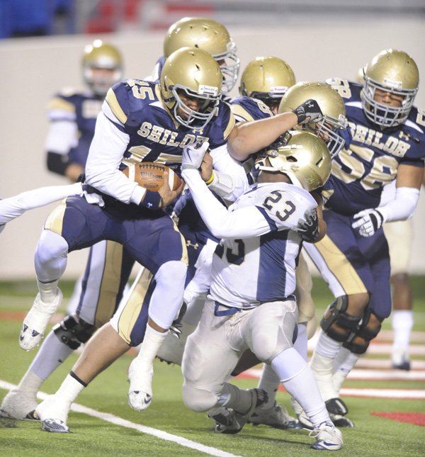 Shiloh Christian senior quarterback Kiehl Frazier carries the ball into the end zone as Pulaski Academy frehsman linebacker Tyler Colquitt reaches to make the tackle Friday, during the first half of the Class 4A State Championship Game in Little Rock.
