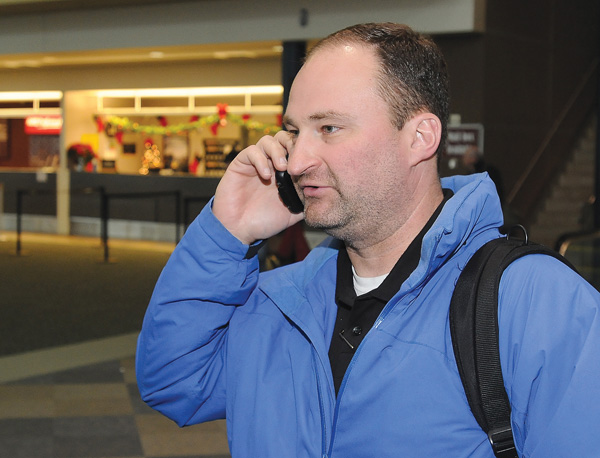 Navy Cmdr. Ted Sego calls his family to let them know of his arrival at Northwest Arkansas Regional Airport on Christmas Eve in Bentonville. Sego reported an easy flight with no delays from Norfolk, Va.