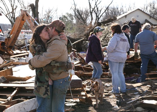 Kent Kucera kisses his girlfriend, Naomi Vaughn, at friend Chris Sisemore’s house on Friday. The Sisemore home was destroyed by a tornado that hit the Cincinnati community. Kucera and Vaughn were there to help clean up debris. Kucera and Vaughn live in a mobile home down the street from the house and felt the tornado.
