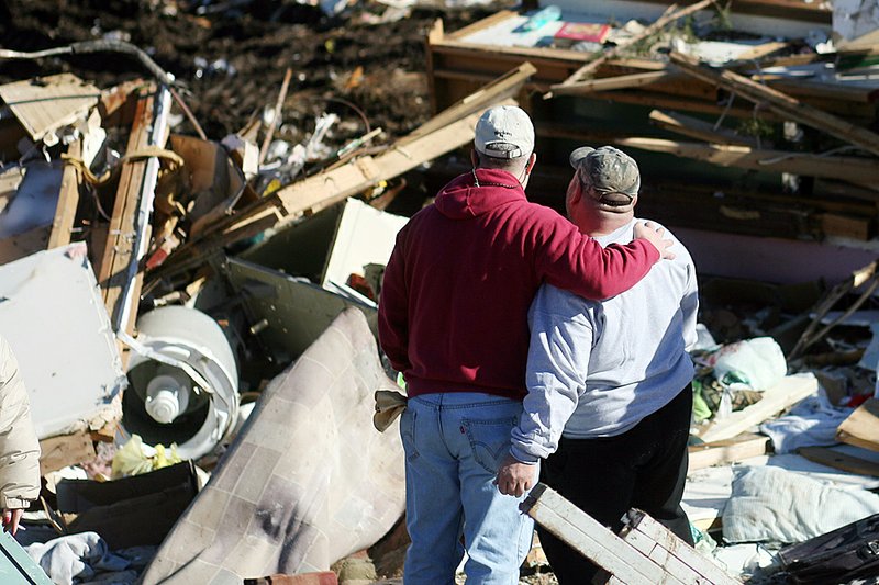 Arthur Thurman (left) of Fayetteville and his brother-in-law Richard Grubbs survey the remains of Grubbs’ Cincinnati home Saturday. 