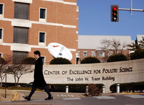 A pedestrian Thursday crosses Stadium Drive along Maple Avenue in front of the Center of Excellence for Poultry Science at the University of Arkansas at Fayetteville. Tyson’s is a familiar name on campus facilities. The John W. Tyson Building, the flagship facility of the Center of Excellence for Poultry Science, honors Don Tyson’s father and founder of Tyson Foods Inc.