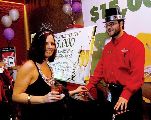 Danielle Wilson of Hot Springs enters her name into the drawing while Oaklawn employee Alex Frye looks on Dec. 31 during the $5,000 New Year's Eve Extravaganza at Oaklawn Park.