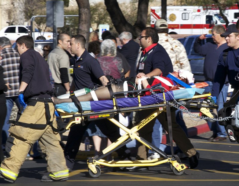 In this Jan. 8, 2011, file photo, emergency personnel and Daniel Hernandez, an intern for U.S. Rep. Gabrielle Giffords, move her after she was shot in the head outside a shopping center in Tucson, Ariz. The shooter. Jared Loughner, plead guilty to 19 of 49 charges in court on Tuesday.