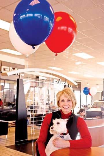 Susie Everett holds Beau, a schnauzer who comes to work with her every day, in the showroom at Everett Buick GMC. Everett is known as the “face” of the family-owned dealership.