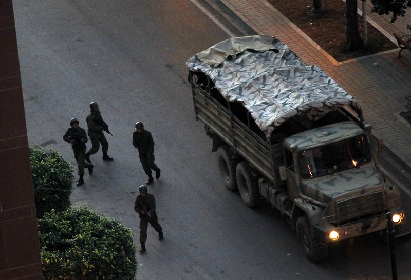 Soldiers take position as gunfire echoes through the capital in the center of Tunis, Sunday, Jan. 16. 2011. Tunisia sped toward a new future after its iron-fisted leader fled, with an interim president sworn in and ordering the country's first multiparty government to be formed. 