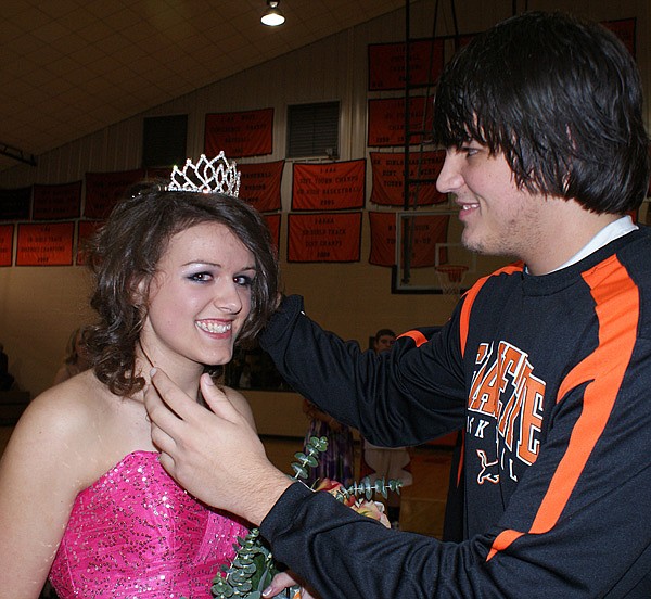 Gravette Lion Cody Montee adjusts the crown for Homecoming Queen Samantha Van Otterloo after she was presented her traditional bouquet by her other escort, Matthew Van Otterloo. 
