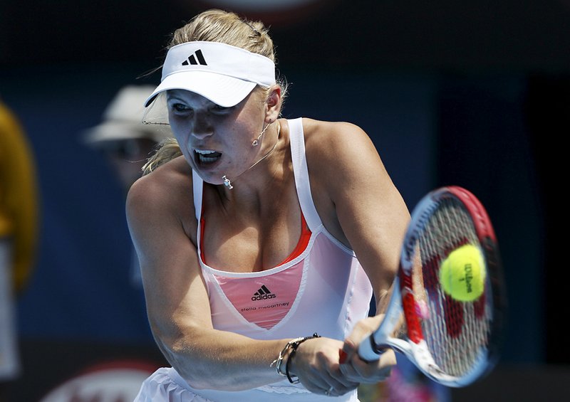 Top-seeded Caroline Wozniacki of Denmark hits a backhand return during Thursday’s 6-4, 6-3 third-round victory over No. 29 seed Dominika Cibulkova of Slovakia at the Australian Open in Melbourne. 
