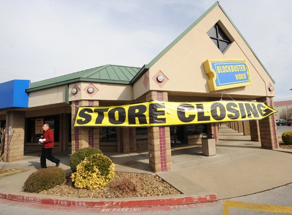 A patron leaves the Blockbuster store at 3112 N. College Ave. in Fayetteville Jan. 19 amid signs of the store’s closing.
