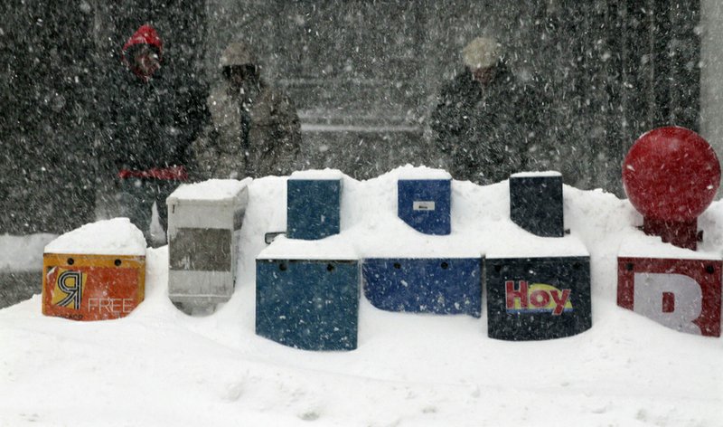 Newspaper boxes sit in a snow bank, Wednesday, Feb. 2, 2011, in Chicago, after a blizzard dumped nearly 20 inches of snow on the area overnight. 