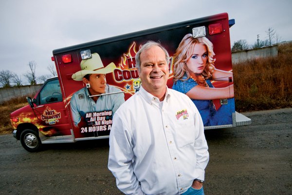 Sid King of Clinton stands near his “jambulance,” a converted ambulance that plays music. King purchased the jambulance several years ago and brings it to community events in the Clinton area to promote his radio station.