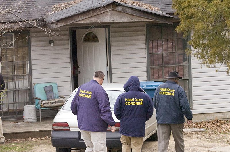 Coroner’s office employees prepare to enter the residence at 2512 S. Summit St. in Little Rock, the scene of a double homicide Feb. 3.

