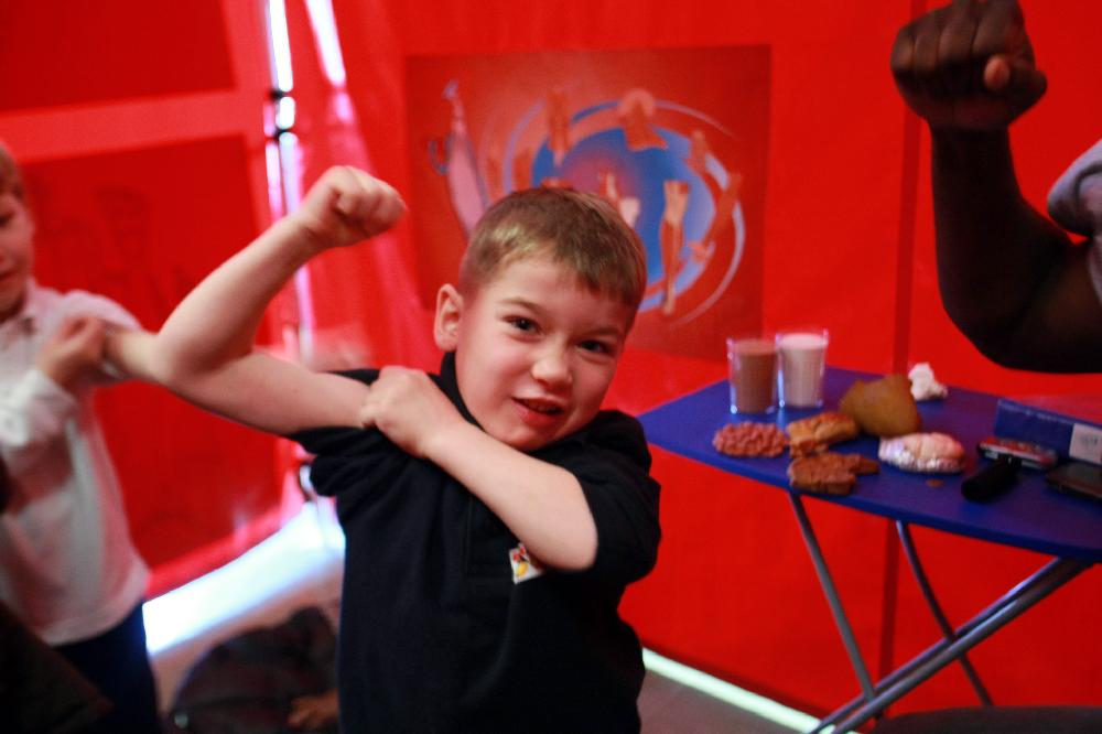 Arkansas Democrat-Gazette/RICK MCFARLAND--02/07/11-- C.J. Malone, kindergarten student, shows off his muscles at the nutrition station for Body Walk, a 30 ft by 36 ft walk-through exhibit that visited Dupree Elementary School in Jacksonville Monday. The exhibit is operated by the University of Arkansas Division of Agriculture Cooperative Extension Service.