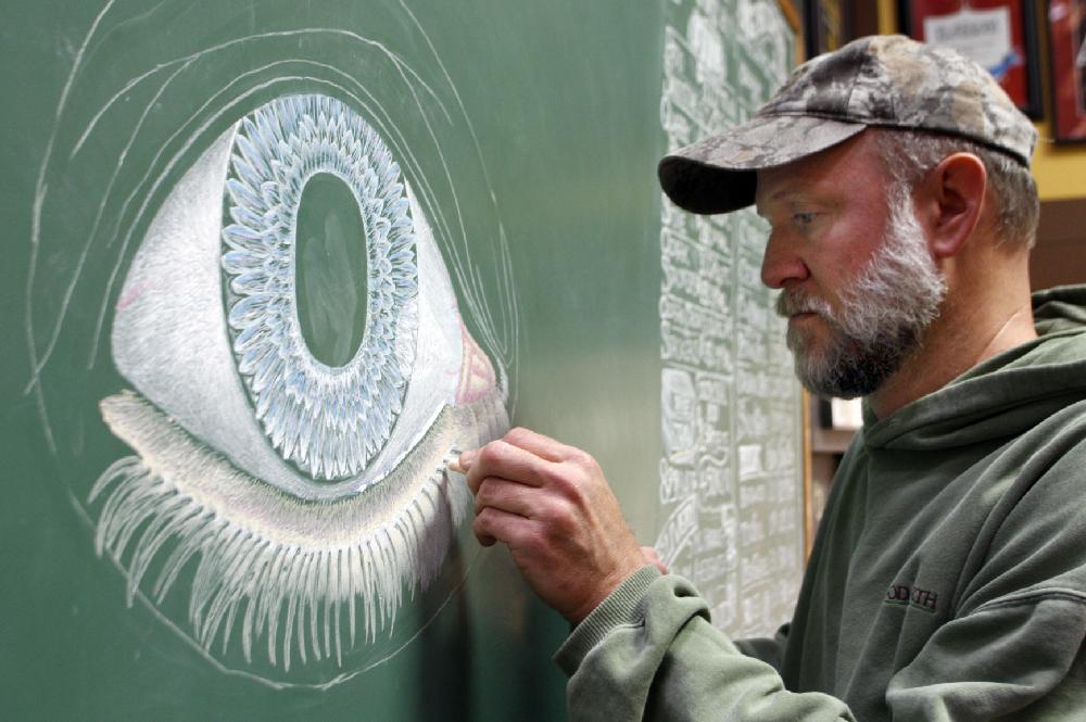 Arkansas Democrat-Gazette/JEFF MITCHELL --02/07/11-- Don Niemann, an employee at The Good Earth Garden Center, starts a fresh image using chalk on the garden center's specials board behind the cash register at the nursery on Cantrell Road in west Little Rock, February 7, 2011. Niemann works up four images a year depicting the seasons, and will spend about 30 hours to complete the Spring drawing he started Monday.
