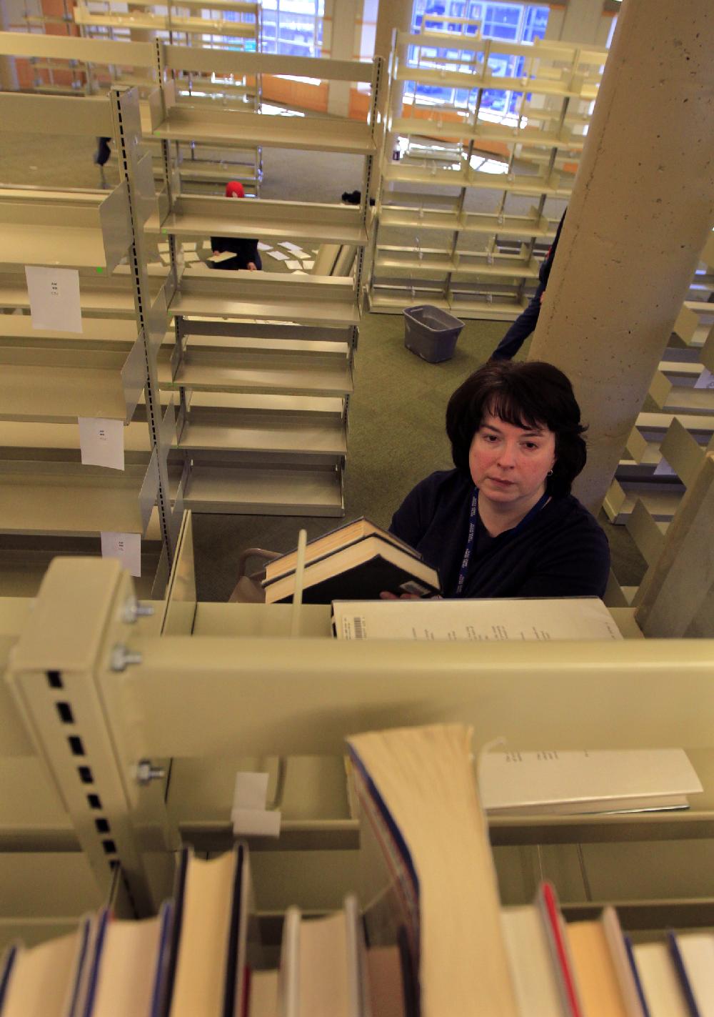 Arkansas Democrat-Gazette/BENJAMIN KRAIN --1/27/11--
Carol Coffey and other Central Arkansas Library System workers move some 200,000 books from the first floor to the newly-remodeled 5th floor of the Main Library branch in downtown Little Rock.