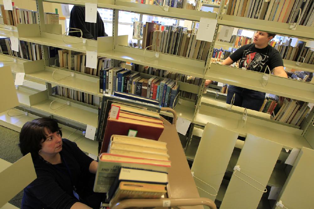 Arkansas Democrat-Gazette/BENJAMIN KRAIN --1/27/11--
Carol Coffey, left, Jasmine Jobe and other Central Arkansas Library System workers move some 200,000 books from the first floor to the newly-remodeled 5th floor of the Main Library branch in downtown Little Rock.