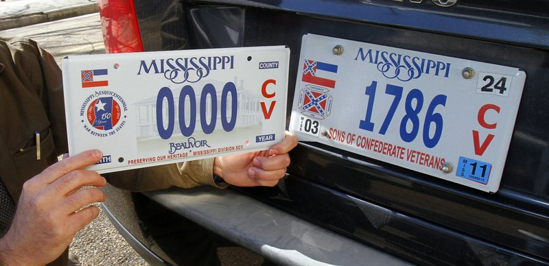 Greg Stewart, a member of the Mississippi Division, Sons of Confederate Veterans, displays a sample of the latest Civil War sesquicentennial tag that is being sold, left, adjacent to the current tag in Jackson, Miss., Tuesday, Feb. 8, 2011. 