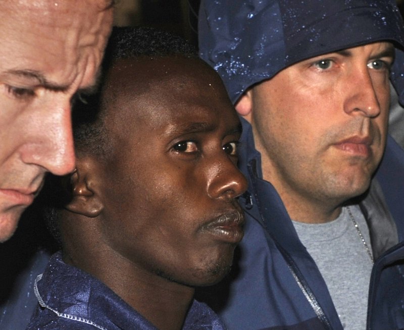 In this April 20, 2009 file photo, FBI agents escort Abdiwali Abdiqadir Muse into FBI headquarters in New York. 