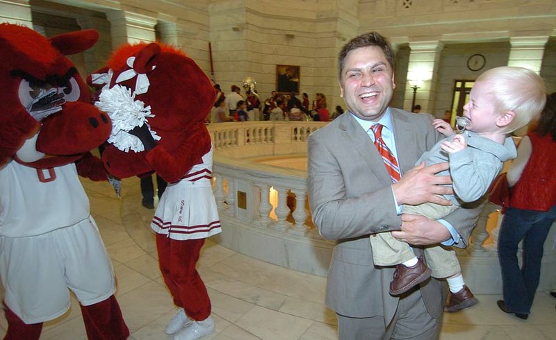 State Sen. Jonathan Dismang, R-Beebe, holds his son, Sawyer, who was frightened by the University of Arkansas Razorback mascots Wednesday during Razorback Day at the Capitol.

 
