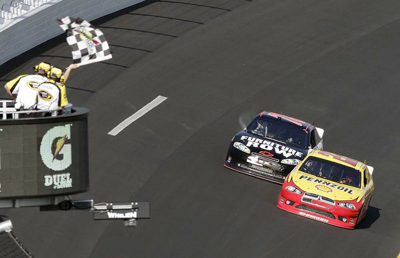 Kurt Busch takes the checkered flag (above) ahead of Regan Smith on Thursday in the first of two 150-mile qualifying races at Daytona International Speedway in Daytona Beach, Fla.. In the second race (below), Jeff Burton (31) squeaked by Clint Bowyer by .005 seconds for the victory.