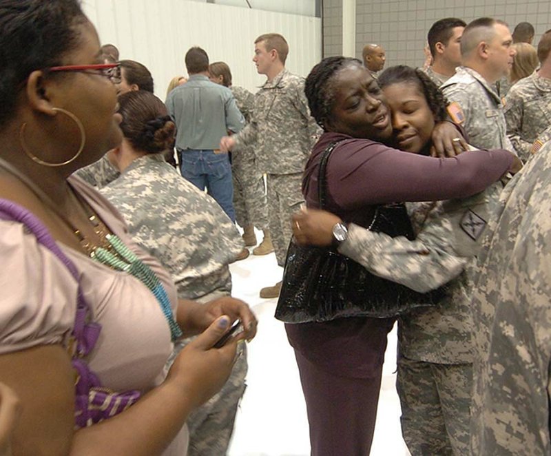 Kaye Rainey (left) embraces her niece Sgt. Kametia Smith after a Thursday deployment ceremony held at Camp Robinson in North Little Rock for the Arkansas National Guard’s 77th Theater Aviation Support Brigade. 
