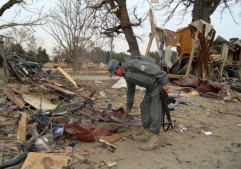 An Afghan policeman works Friday amid the rubble after a suicide explosion in Khost. 