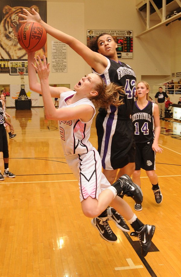 Bentonville’s McKinzie James shoots a layup as Fayetteville’s Brittany Austin attempts to block the shot Friday in Tiger Arena in Bentonville.
