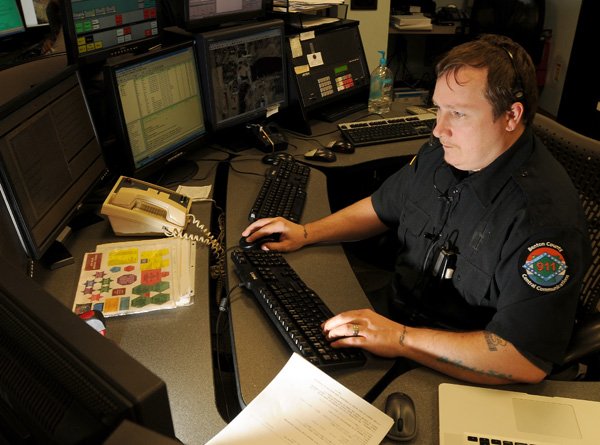 Jeff Young, Benton County Central Communications supervisor, works at his desk Friday in the basement of the County Administration Building in Bentonville. Dispatches of emergency services in the county numbered about 90,000 in 2010, up from 57,000 in 2006.
