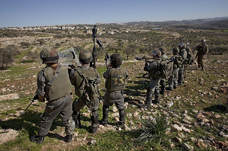 Israeli police take position Friday in the West Bank village of Bilin as protesters begin their weekly demonstration against Israel’s separation barrier. 