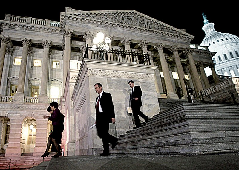 U.S. congressmen leave the House of Representatives, where they worked through the night Friday on a spending bill. 