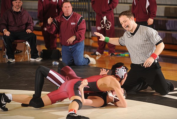 John Pearson of Bentonville, right, counts as Springdale High junior Jonathan Chan, left, pins Gentry junior Tyler Easter in a 119-pound division match on Feb. 12 during a tournament at Fayetteville High School.
