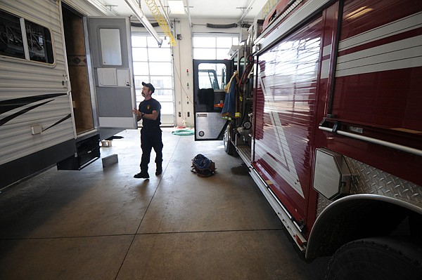 Mike Lewis, a Fayetteville firefighter, closes the door on a camper trailer Thursday at Station No. 3. The station had to be closed after mold was discovered in the wall and ceiling last year. The fire crews have been sleeping in the engine bay in the camper while the remodeling work was being completed in the crew’s quarters.
