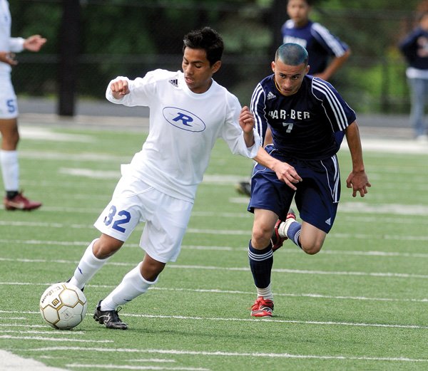 Rogers sophomore Eduardo Ramirez pushes upfield as Har-Ber senior Uriel Sandoval pursues during the 7A state tournament at Gates Stadium in Rogers. The Mountaineers won 2-0.