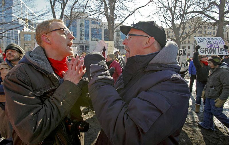 A state-worker-union advocate (left) and Tea Party supporter argue Saturday outside the Wisconsin Capitol over sections of the governor’s proposed budget bill. 