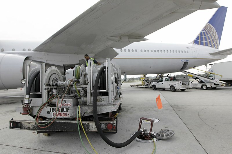 In this April 16, 2010 file photo, a Continental Airlines plane is fueled at George Bush Intercontinental Airport in Houston. For the first time since late 2008, airlines are adding fuel surcharges _ extra fees to cover the price of gas. For those with spring and summer travel plans, it's a one-two punch. 
