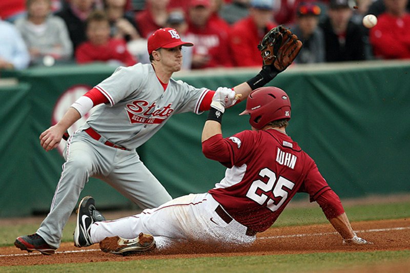 Arkansas’ Collin Kuhn slides safely into third base during the Razorbacks’ 10-0 victory over Delaware State on Sunday at Baum Stadium in Fayetteville. 
