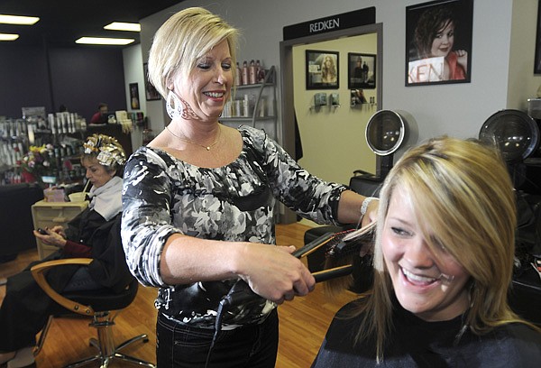 Sharon Brown, owner of Brown All Over Tanning and Salon, straightens Summer Murillo’s hair on Friday in Bentonville.