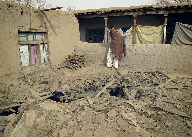  An Afghan youth looks at the damage caused during a raid by NATO’s forces Monday in Khogyani district, Nangarhar province, east of Kabul.