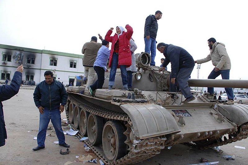  A tank inside a security forces compound serves as a gathering place for residents of Benghazi, Libya’s second largest city, where protesters claimed control Monday. 