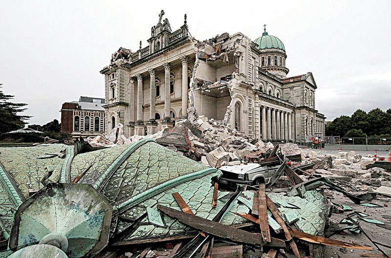 A crushed car sits in rubble from the Christchurch Catholic Cathedral, which was heavily damaged by the strong earthquake that struck the New Zealand city Tuesday.