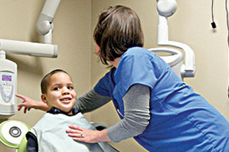 Dental assistant Tamara Love (photo above) helps Nicholas Brown, 5, get comfortable in a frog-shape chair before X-rays at Kitchens Pediatric Dentistry in Little Rock last week. 