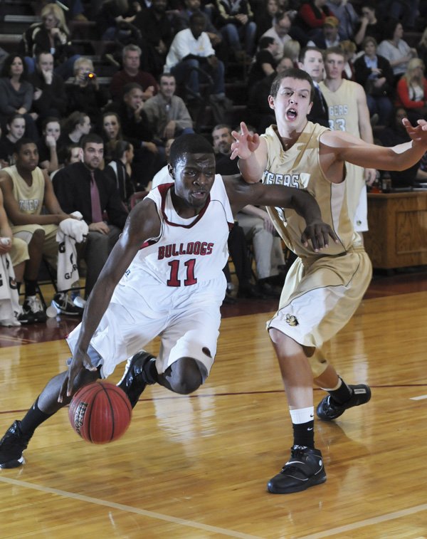 Springdale High’s Curtis Evans drives past Bentonville’s Nick Smith in the first half Tuesday in Springdale.