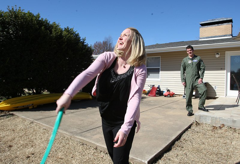 Megan Glynn, recognized by Military Spouse as 2011 Air Force Military Spouse of the Year, tosses a ball to her dogs at her home on Little Rock Air Force Base in Jacksonville, while her husband, Matt, watches. 