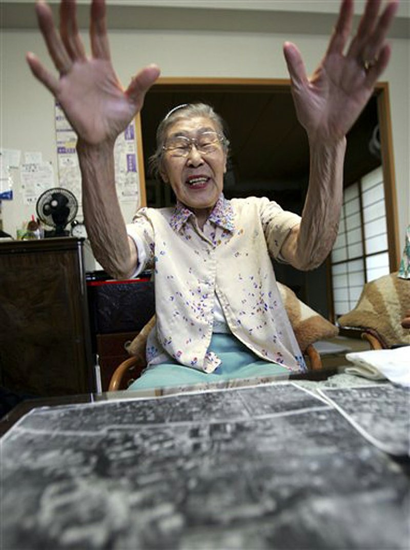 Toyo Ishii, a former military nurse, examines aerial maps of Tokyo as she talks about Unit 731, Japan’s germ and biological warfare outfit during World War II, in this 2006 photo. 