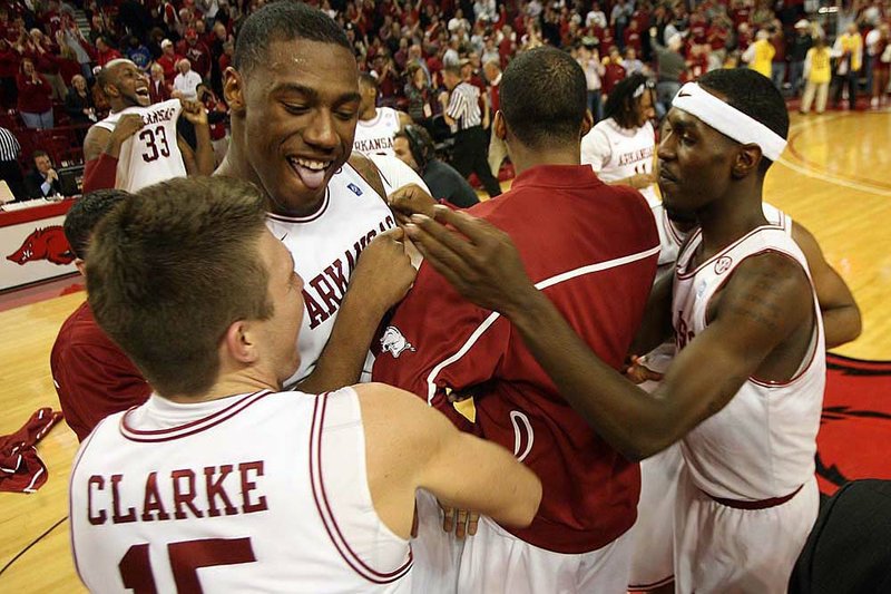 Rotnei Clark (left), who led Arkansas with a game-high 26 points, celebrates with teammates after the Razorbacks ended a 10-game losing streak against Kentucky with a 77-76 overtime victory.

