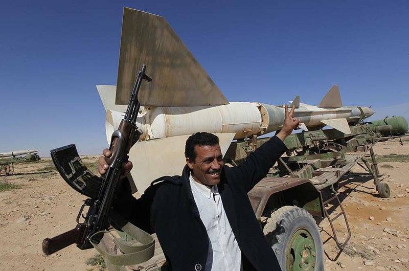 A member of a civilian defense committee celebrates Wednesday as he helps take over guarding a once hidden anti-aircraft missile at an abandoned military base outside Tobruk. 